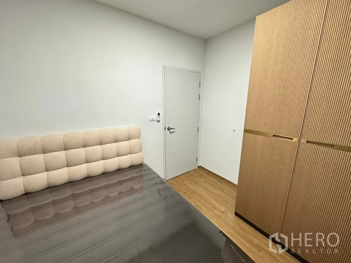Townhouse for rent in Bang Phli, Samut Prakan - Guest bedroom with padded headboard and tall built‑in wardrobe.