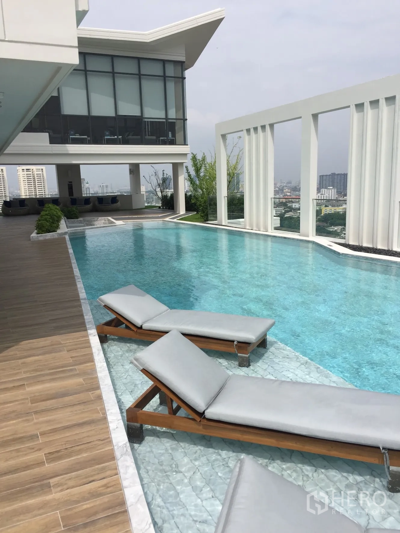 Condominium for rent in Watthana, Bangkok - Rooftop infinity pool with in-water loungers and city views.