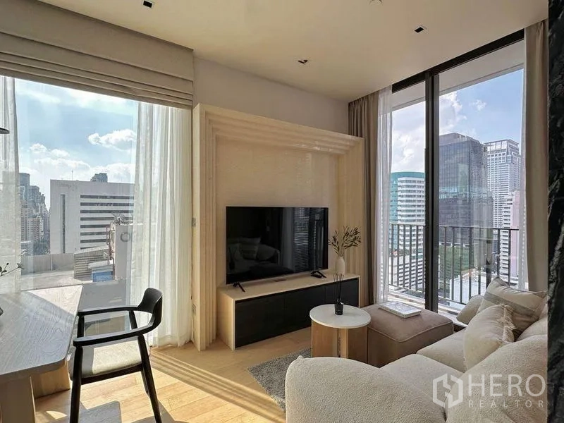 Condominium for rent in Pathum Wan, Bangkok - Close-up of indoor plant by a balcony window with views of a neighboring building.