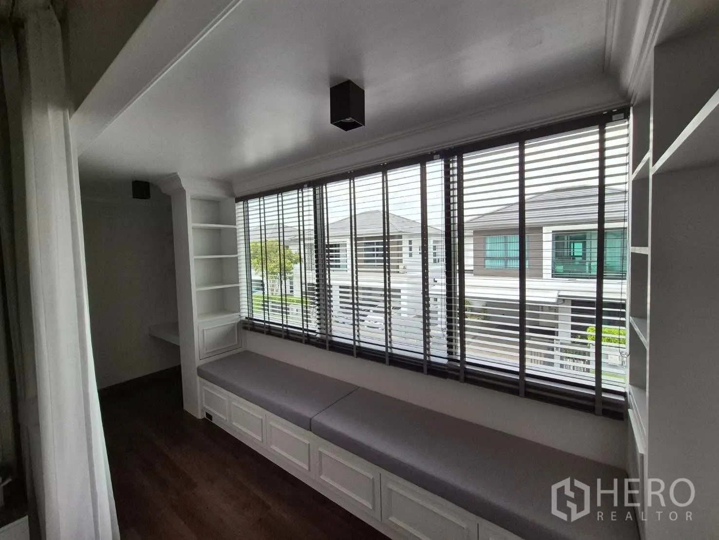 Detached House for sale in Bang Kruai, Nonthaburi - Upstairs nook with long window seat, shelving and wide windows with blinds.