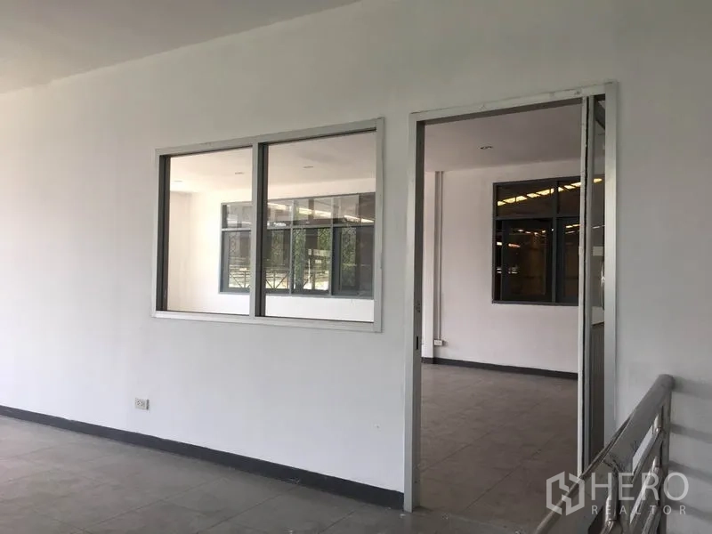 Warehouse for rent in Prawet, Bangkok - Bright upper-level office rooms with large windows overlooking the warehouse floor.