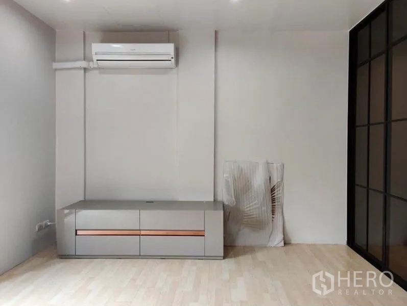 Townhouse for rent in Suan Luang, Bangkok - Bedroom wall with air-conditioning unit and low built-in cabinet