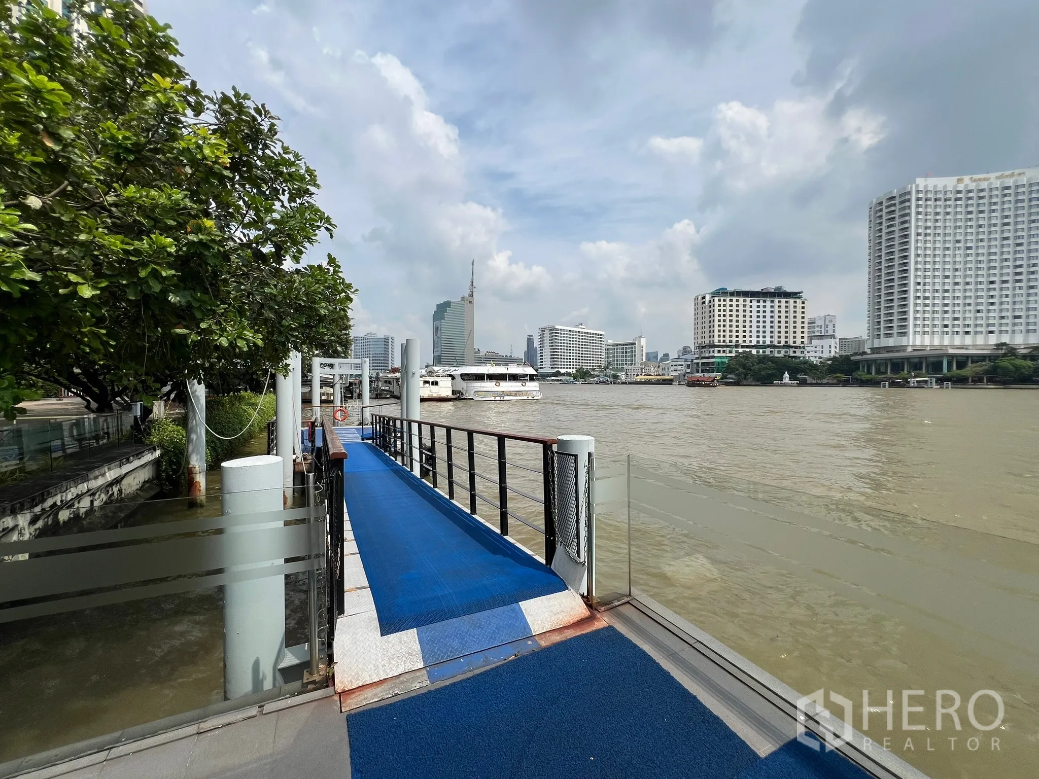 Condominium for sale in Khlong San, Bangkok - Private riverside pier on the Chao Phraya River with city buildings beyond.