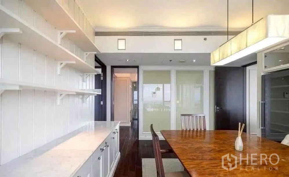 Condominium for rent in Sathon, Bangkok - Dining room with wood table, white built-in shelving and modern pendant lighting.