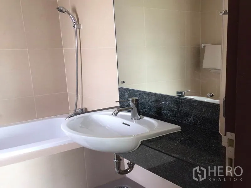 公寓 出租在Watthana, Bangkok - 现代浴室，设浴缸、手持花洒、大镜与石质台面洗手盆。