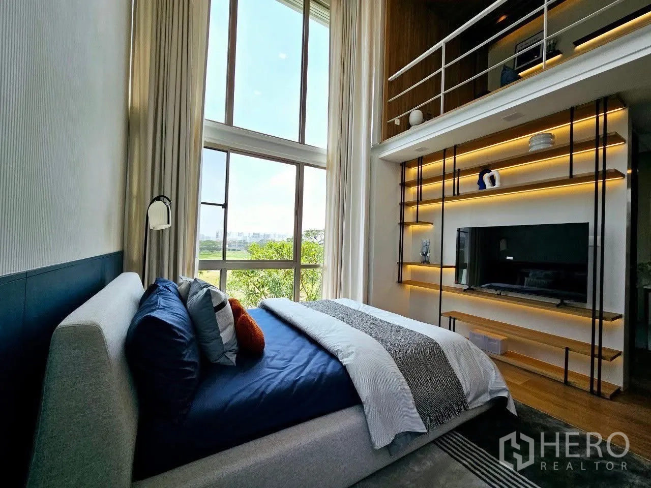 Detached House for rent in Saphan Sung, Bangkok - Double-height bedroom with loft, large window, and illuminated shelving.