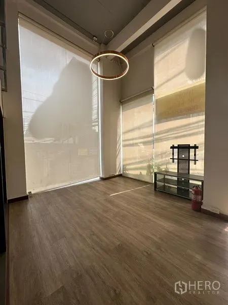 办公空间 出租在Pathum Wan, Bangkok - 挑高房间，木地板，落地窗与卷帘，搭配环形吊灯。