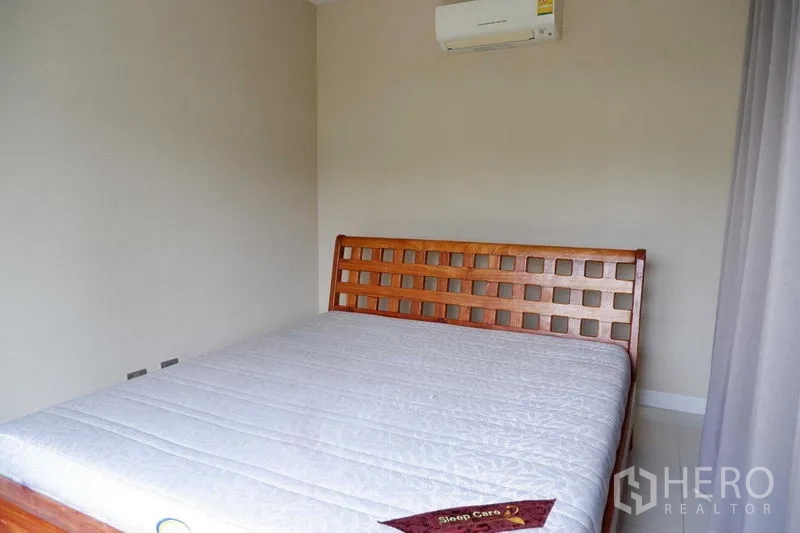 独立式住宅 出售在Lat Krabang, Bangkok - 温馨卧室，木质床架、大窗与壁挂空调
