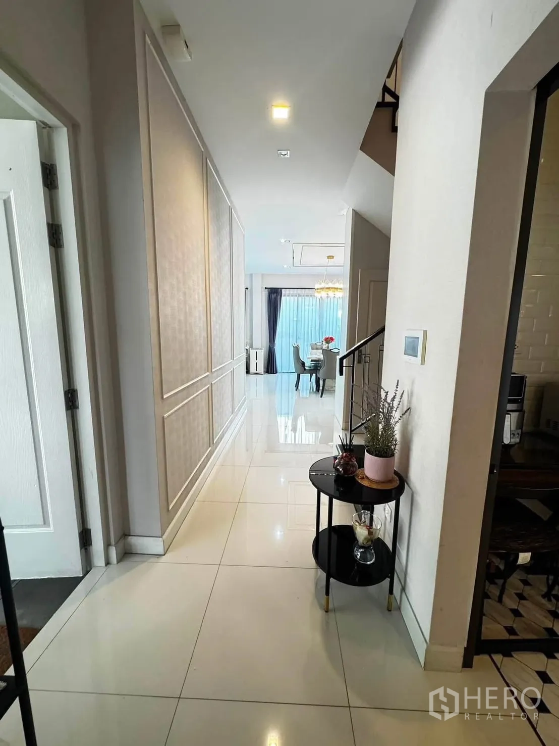 Detached House for rent in Saphan Sung, Bangkok - Hallway with glossy tiles leading toward the dining area and staircase.