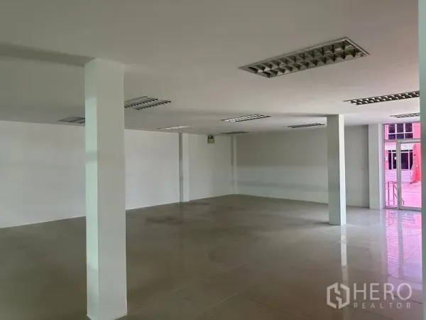Warehouse for rent in Mueang Samut Prakan, Samut Prakan - Flexible office workspace with grid lighting and columns near the main entrance.