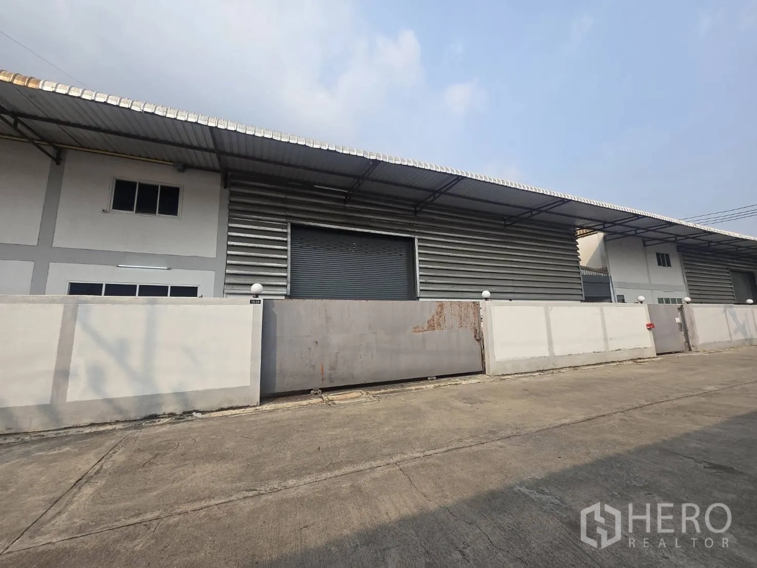 โรงงาน for rent or sale in Mueang Samut Sakhon, Samut Sakhon - แถวอาคารโรงงานผนังเมทัลชีทพร้อมประตูม้วนและกำแพงรอบโครงการ