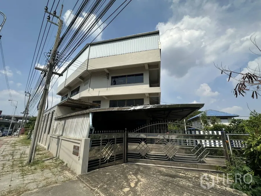 Home Office for rent in Taling Chan, Bangkok - Three-storey standalone home office and warehouse with a wide metal gate and perimeter fence in Taling Chan, Bangkok.