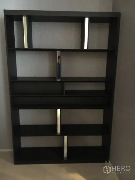 Detached House for rent in Wang Thonglang, Bangkok - Tall black open bookshelf with geometric shelves against a gray wall.
