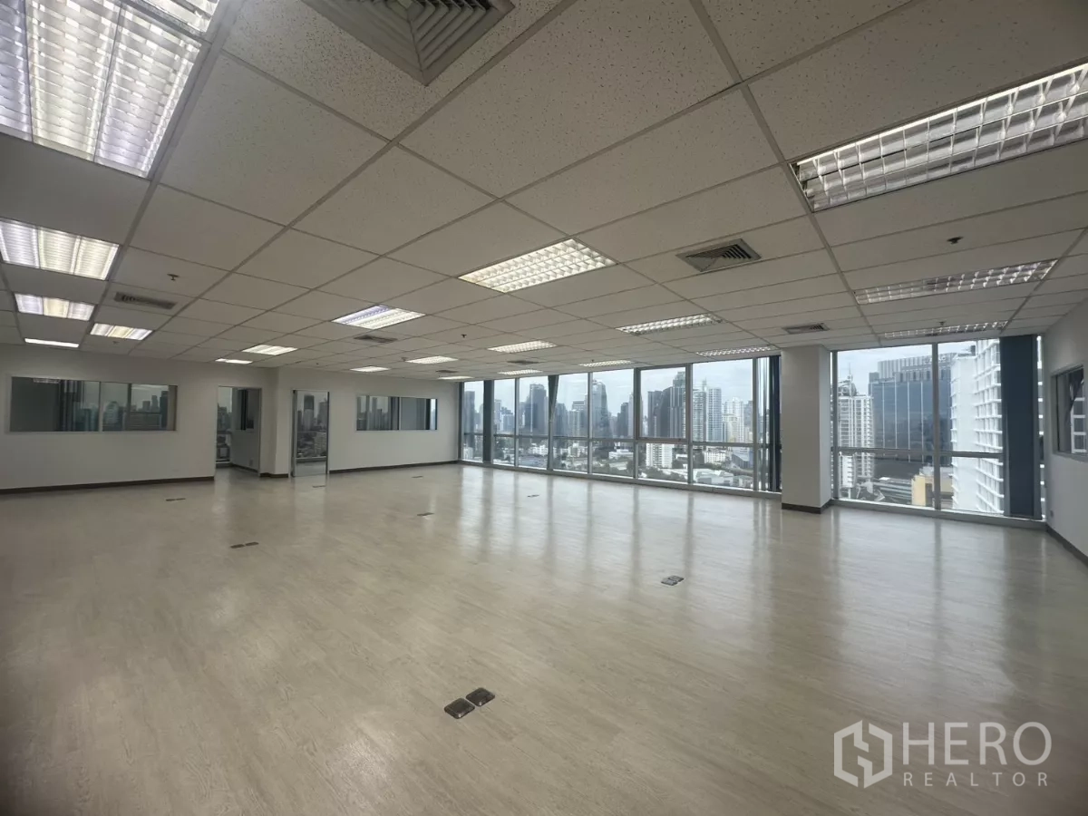 办公空间 出租在Khlong Toei, Bangkok - 明亮的开放工位区，转角玻璃与吊顶灯具