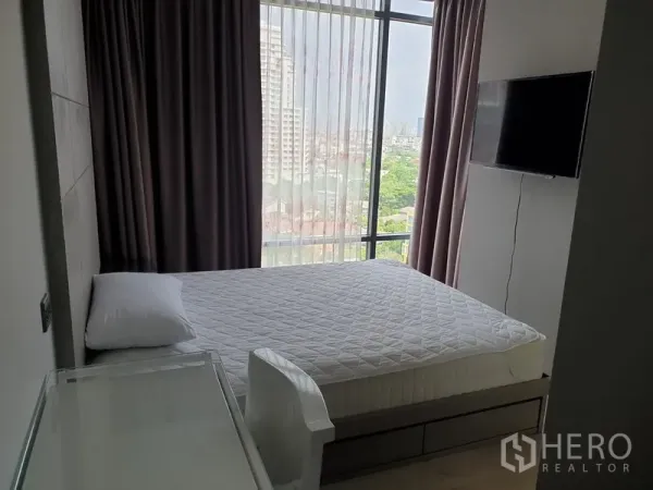 公寓 出租在Watthana, Bangkok - 主卧配床与壁挂电视，落地窗帘，享城市天际线景观。
