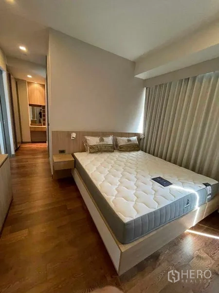 Condominium for rent or sale in Bang Rak, Bangkok - Master bedroom with king-size bed, bedside tables, and curtains.
