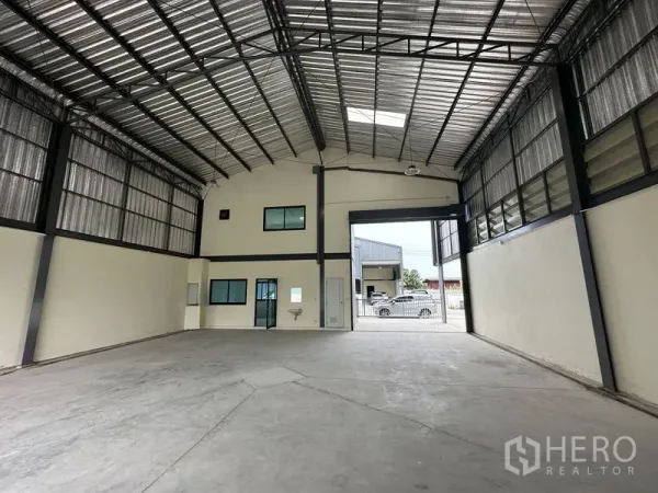Factory for rent or sale in Bang Yai, Nonthaburi - Warehouse interior with 8-meter high steel roof, skylight and large roller door.