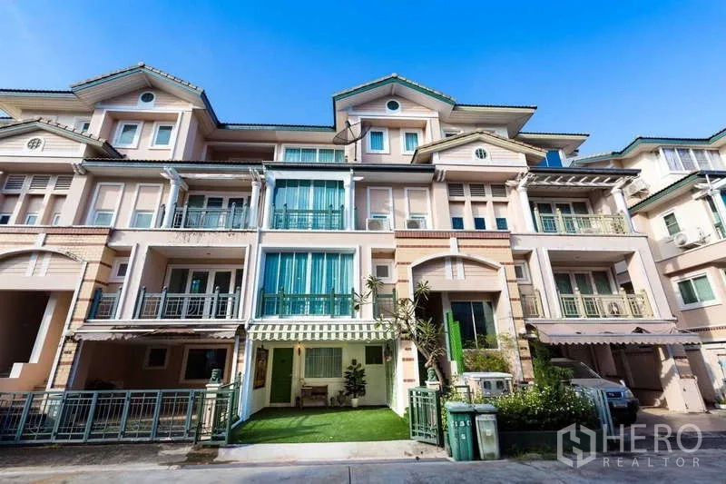 Townhouse for rent in Lat Phrao, Bangkok - Townhouse street-facing facade with multiple balconies, awning and a small green lawn.