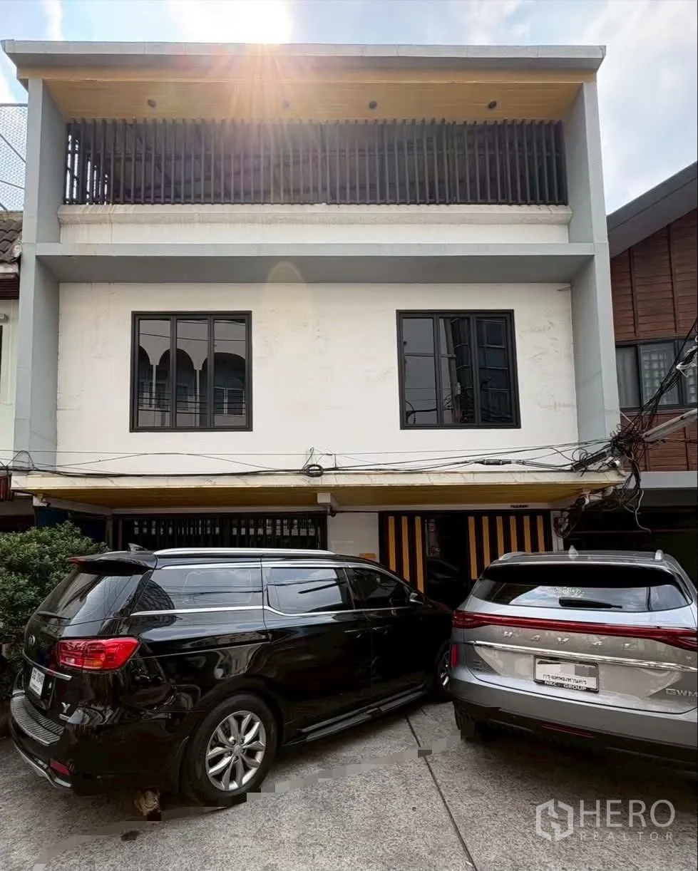 ทาวน์เฮาส์ for rent in Pathum Wan, Bangkok - ด้านหน้าทาวน์เฮ้าส์มีระเบียงชั้นบนแบบซี่กรงและพื้นที่จอดรถสองคัน.
