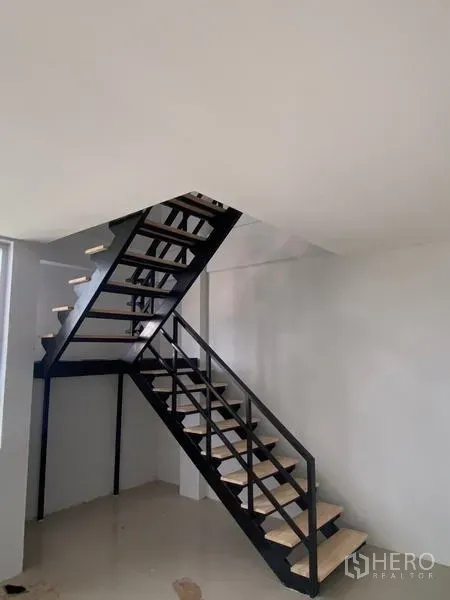 Warehouse for rent in Bang Phli, Samut Prakan - Black steel staircase leading to a mezzanine office inside the warehouse.