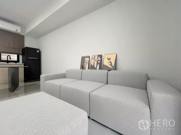 Townhouse for rent in Bang Phli, Samut Prakan - Cozy seating area with modular grey sofa beside a pantry and refrigerator.