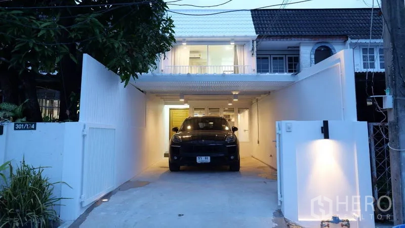 ทาวน์เฮาส์ ให้เช่าในKhlong Toei, Bangkok - ด้านหน้าทาวน์เฮ้าส์มีทางรถเข้า โรงจอดรถ และระเบียงชั้นบนตอนค่ำ