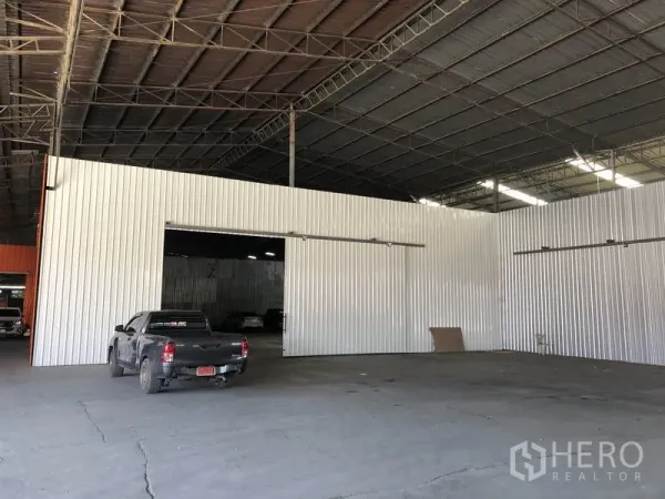 Warehouse for rent in Nong Chok, Bangkok - Large indoor loading bay in a high-roof warehouse featuring sliding metal doors and open clear-span space.