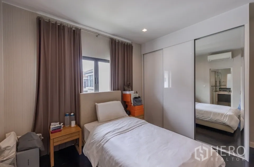 独栋房屋 for rent or sale in Bang Kapi, Bangkok - 温馨卧室，单人床与镜面推拉衣柜门。