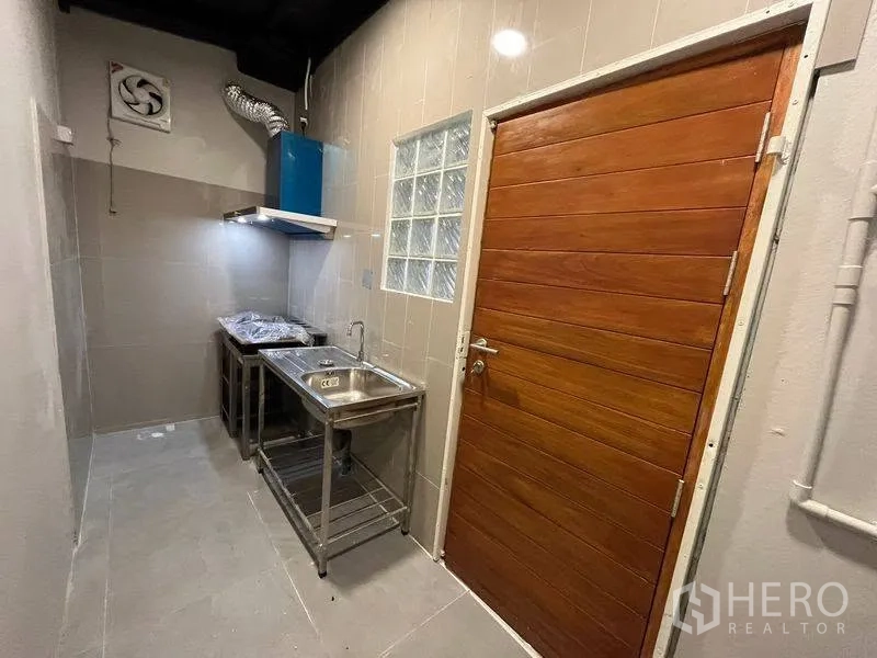 ทาวน์เฮาส์ for rent in Phra Khanong, Bangkok - ครัวขนาดกะทัดรัด อ่างสเตนเลส เครื่องดูดควัน และผนังกระเบื้อง.