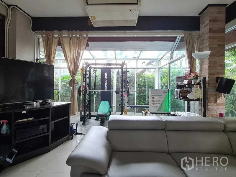 บ้าน ขายในBang Na, Bangkok - โซนรับแขกเชื่อมต่อห้องกระจกสำหรับฟิตเนส มองเห็นสวนเขียว