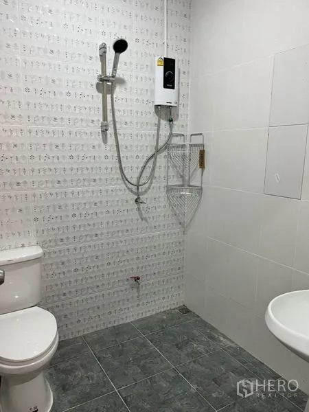 Townhouse for rent in Din Daeng, Bangkok - Tiled bathroom featuring a shower with water heater, toilet, and wall-mounted sink.