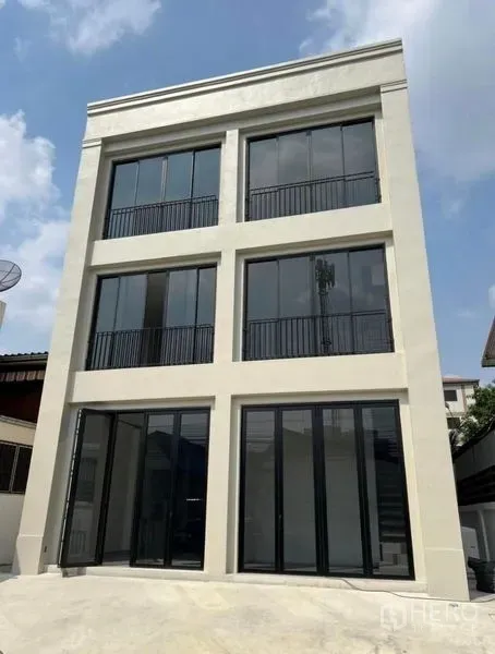 Home Office for rent or sale in Bang Na, Bangkok - Modern three-storey home office exterior in Bang Na with tall black-framed windows and balconies.