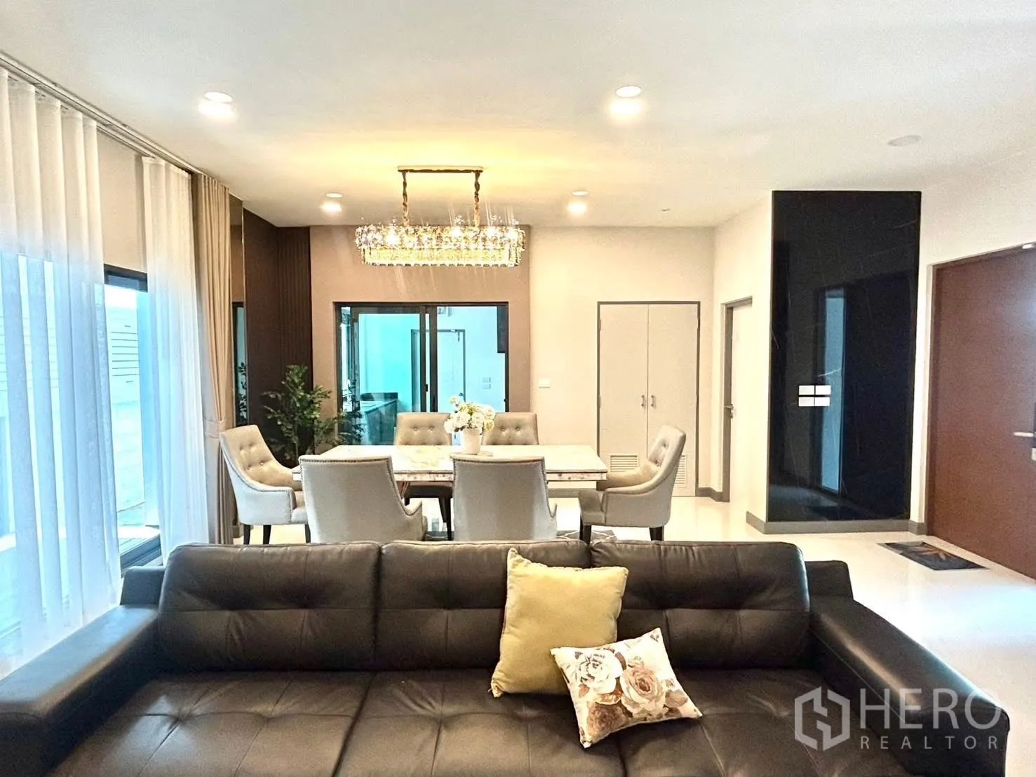 Detached House for rent in Bang Phli, Samut Prakan - View across a leather sofa toward the dining area and sliding glass doors.