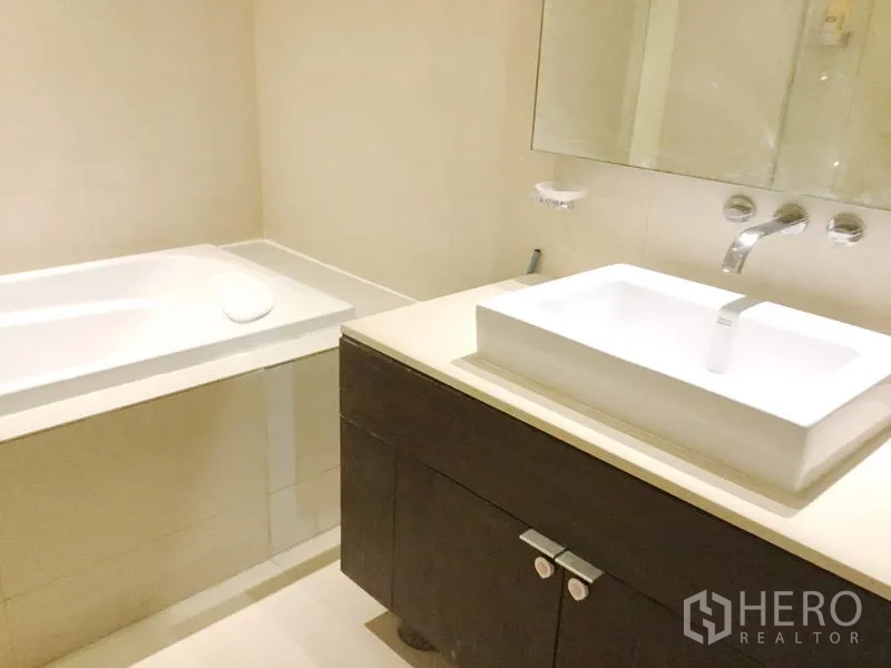 คอนโด ให้เช่าในWatthana, Bangkok - ห้องน้ำสมัยใหม่พร้อมอ่างอาบน้ำ อ่างล้างหน้าทรงสี่เหลี่ยม กระจกบานใหญ่ และกระเบื้องโทนอ่อน