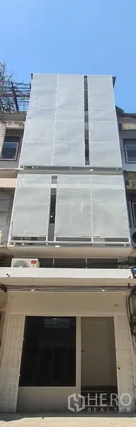 Shophouse for rent in Phra Khanong, Bangkok - Narrow multi-storey shophouse exterior with modern cladding panels above the shopfront.