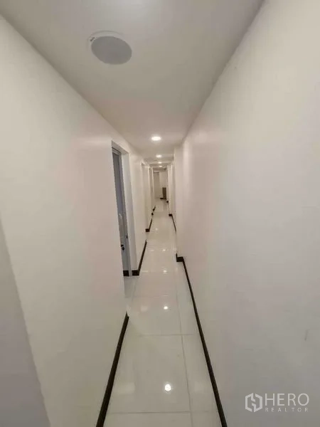 店屋 出售在Watthana, Bangkok - 明亮走廊，白色墙面与多扇房门。