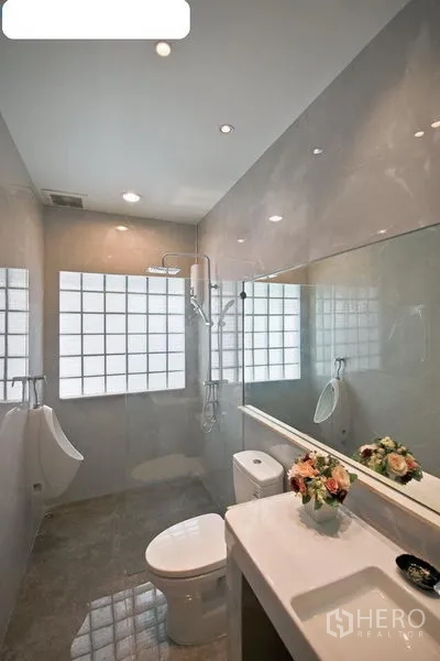 Detached House for rent in Bang Kapi, Bangkok - Modern bathroom with glass-block window, long mirror, shower and white sanitary ware.