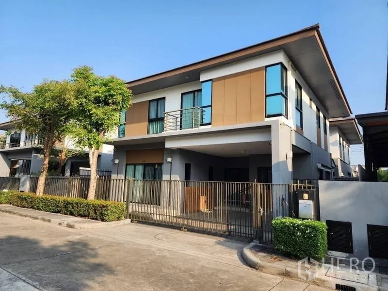 独立式住宅 出租在Prawet, Bangkok - 现代两层独栋住宅，带阳台、入户车位与绿化街景。