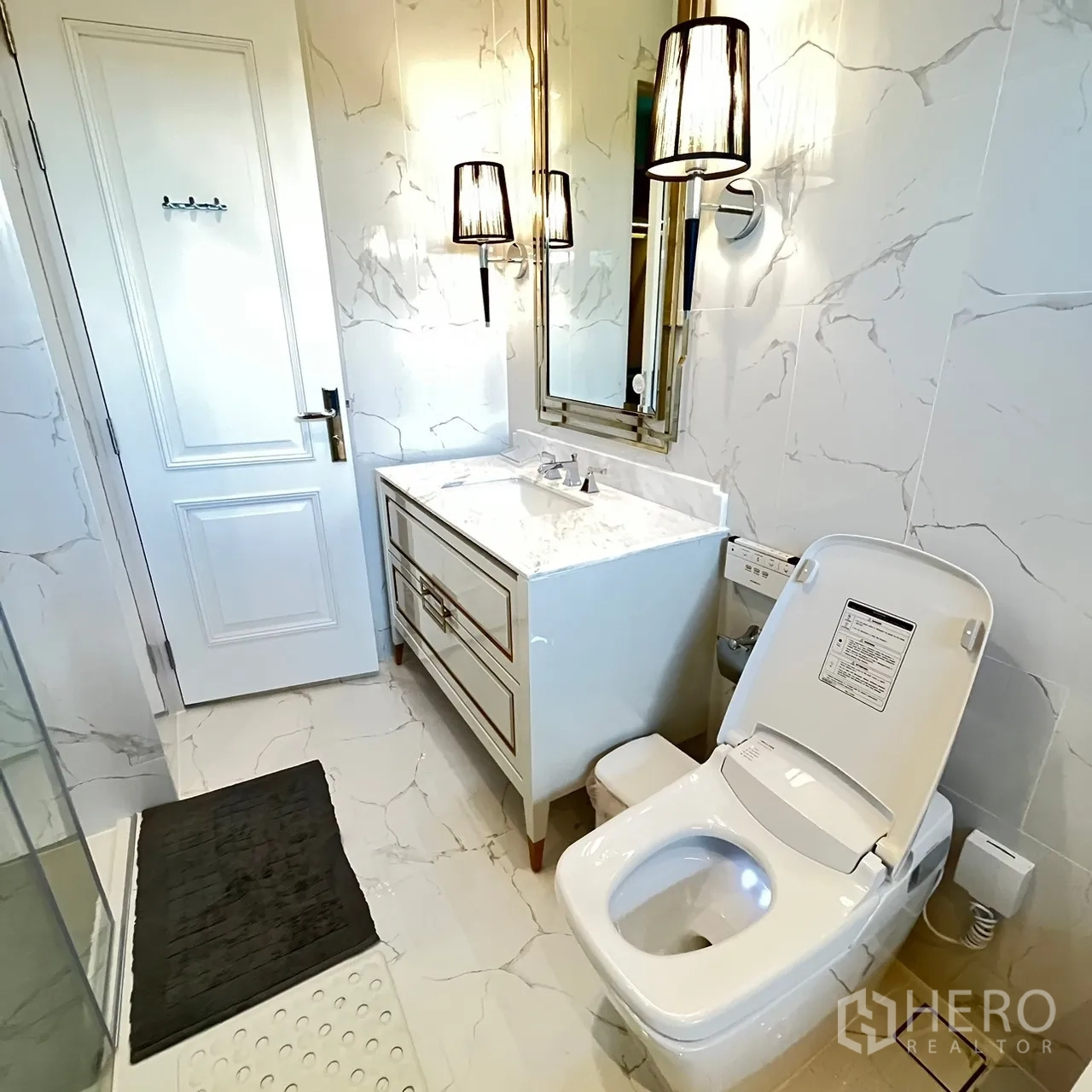 Detached House for rent or sale in Bang Khen, Bangkok - Ensuite bathroom with marble vanity, wall sconces and smart toilet.