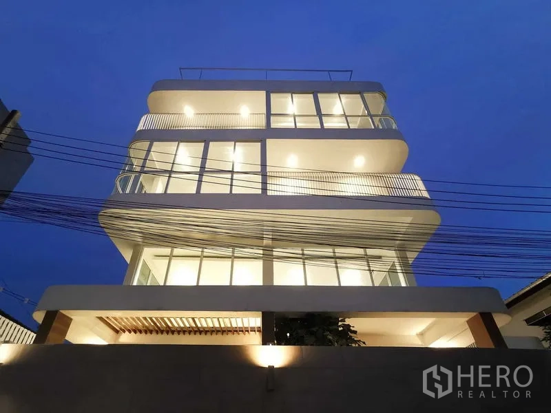 带办公室的家 出售在Suan Luang, Bangkok - 夜间现代多层外立面，圆角阳台