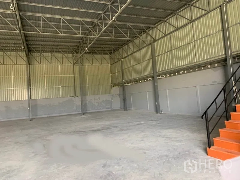 Factory for rent in Khlong Luang, Pathum Thani - Open production hall with mezzanine office stairs and 7–9 m clear height.