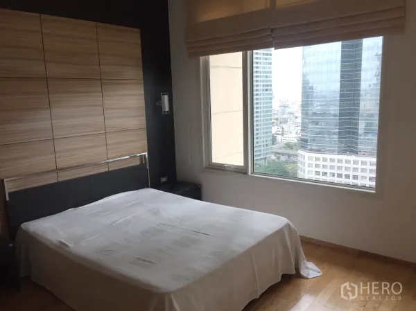 公寓 出租在Sathon, Bangkok - 卧室带大窗与城市景观，木地板温馨舒适。