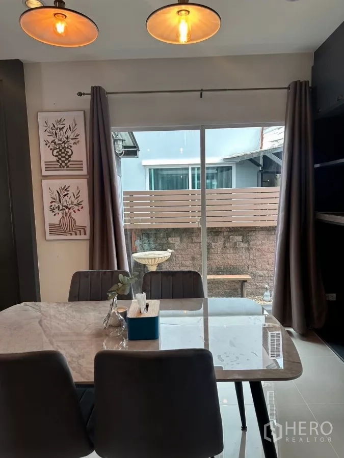 บ้าน ให้เช่าในSuan Luang, Bangkok - มุมรับประทานอาหารพร้อมประตูกระจกบานเลื่อนออกลานเล็ก โคมไฟแขวน และผ้าม่านทึบ.