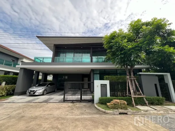 บ้าน ให้เช่าในBang Kapi, Bangkok - ด้านหน้าบ้านสมัยใหม่มีทางรถเข้าและโรงจอดรถพร้อมรั้ว