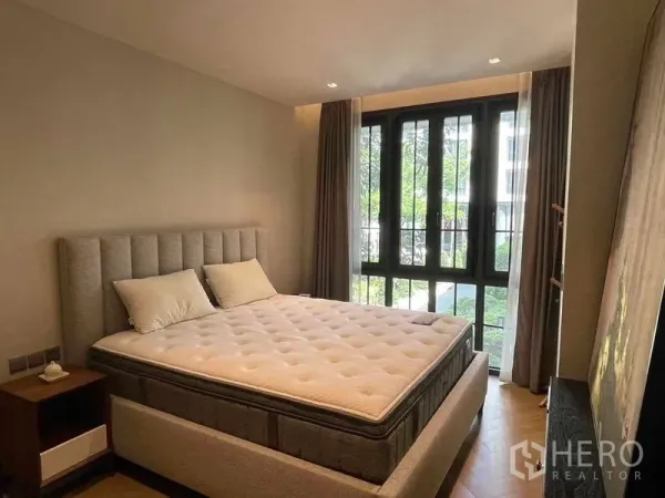 คอนโด ให้เช่า - ห้องนอนสว่าง เตียงบุนุ่ม และหน้าต่างสูงจรดเพดานวิวสวน