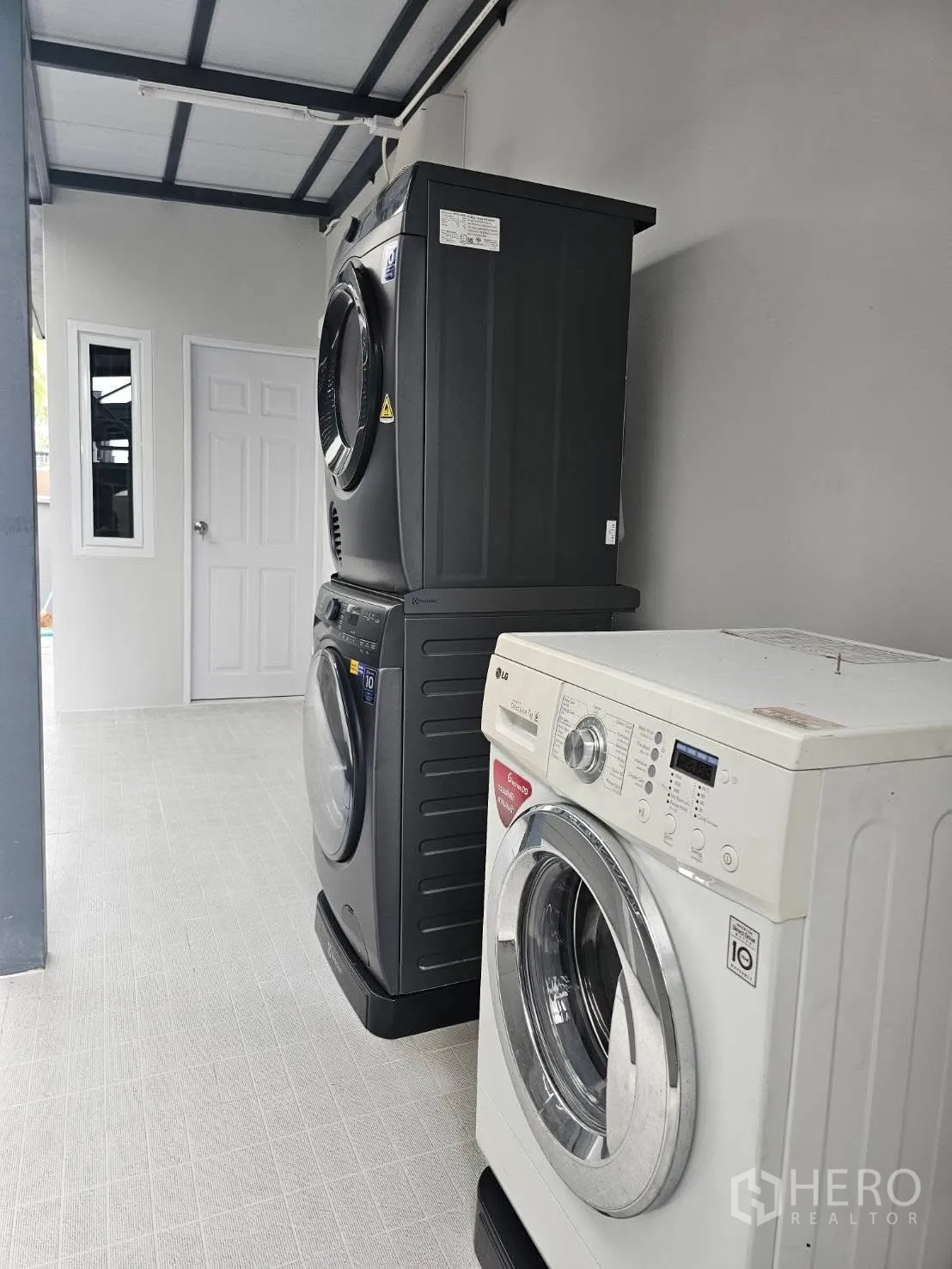 Detached House for rent or sale in Bang Phli, Samut Prakan - Covered laundry area with washing machine and stacked dryer-washer units.