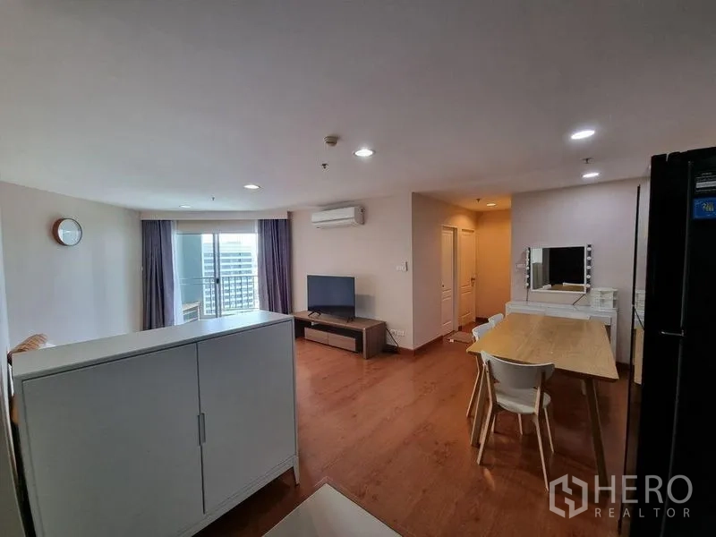 คอนโด ให้เช่าในHuai Khwang, Bangkok - ห้องนั่งเล่นมีประตูระเบียง ชั้นวางทีวี และผ้าม่าน ในคอนโดสูง