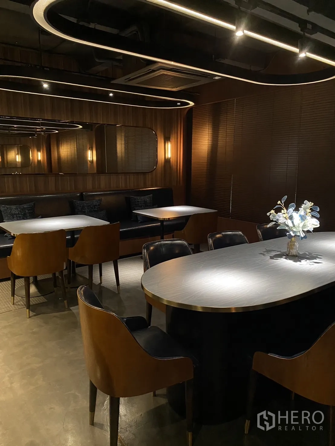 Shophouse for rent in Watthana, Bangkok - Restaurant dining area with banquette seating, oval table and warm wood finishes.