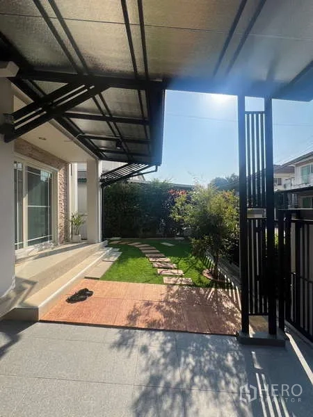 Detached House for rent in Bang Kapi, Bangkok - Covered front terrace opening to a lawn and stepping‑stone path.