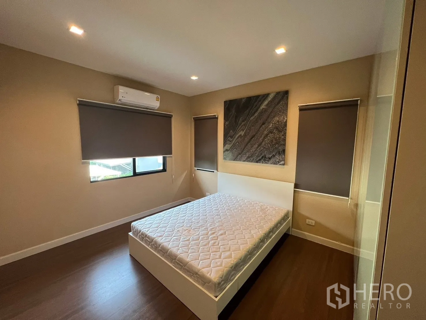 บ้าน ให้เช่าในBang Phli, Samut Prakan - ห้องนอนรองพร้อมเครื่องปรับอากาศ ม่านม้วนกันแสง พื้นไม้ และภาพตกแต่งผนัง